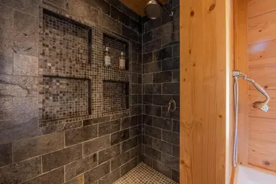 a bathroom with a shower with black tiles at Véroce Chalet Calme 10PAX Cheminee Vue in Saint-Gervais-les-Bains