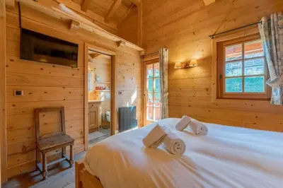 a bedroom with a bed in a log cabin at Véroce Chalet Calme 10PAX Cheminee Vue in Saint-Gervais-les-Bains