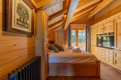 a bedroom with a bed in a wooden cabin at Véroce Chalet Calme 10PAX Cheminee Vue in Saint-Gervais-les-Bains