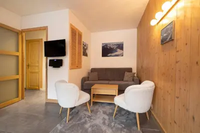 a living room with a couch and a table and chairs at Posette Studio Vue 5mn Pistes Parking in Chamonix-Mont-Blanc