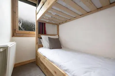 a bed in a small room with a window at Posette Studio Vue 5mn Pistes Parking in Chamonix-Mont-Blanc
