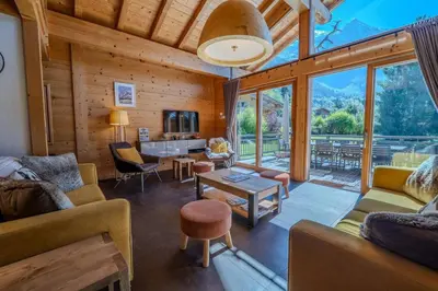 a living room with furniture and a large window at Vieil Ours Douillet Chalet 11pax Familial Vue in Chamonix-Mont-Blanc