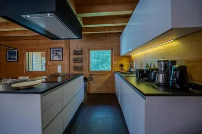 a large kitchen with a counter top in a cabin at Vieil Ours Douillet Chalet 11pax Familial Vue in Chamonix-Mont-Blanc