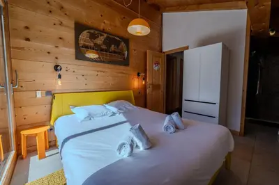 a bedroom with a bed with two pillows on it at Vieil Ours Douillet Chalet 11pax Familial Vue in Chamonix-Mont-Blanc