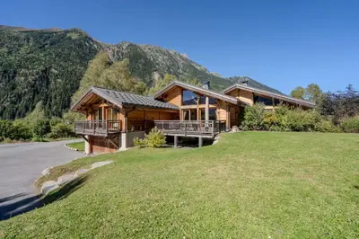 a large wooden house on a hill with a yard at Vieil Ours Douillet Chalet 11pax Familial Vue in Chamonix-Mont-Blanc