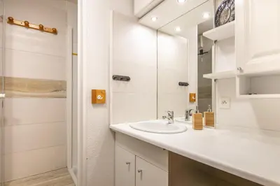 a white bathroom with a sink and a shower at Le Repos du Skieur - Au pied des pistes in Morillon