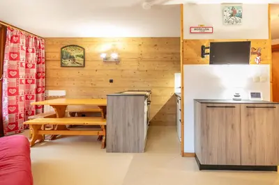 a dining room with a table and a refrigerator at Le Repos du Skieur - Au pied des pistes in Morillon