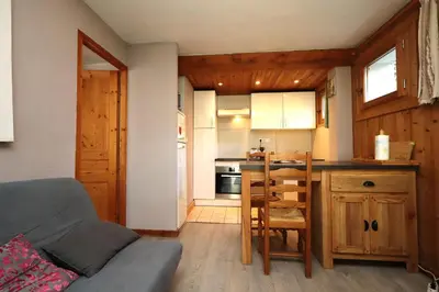 a kitchen with a couch and a table in a room at Appartement 2 pers hyper centre Chamonix in Chamonix-Mont-Blanc