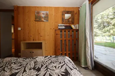 a bedroom with a bed and a wooden wall at Appartement 2 pers hyper centre Chamonix in Chamonix-Mont-Blanc