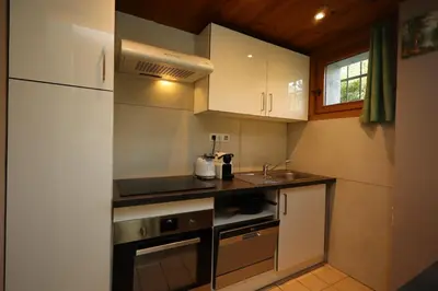 a small kitchen with white cabinets and a sink at Appartement 2 pers hyper centre Chamonix in Chamonix-Mont-Blanc
