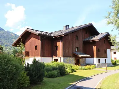a large wooden house in a yard with a driveway at Charmant duplex 7 pers à Samoëns avec piscine et Wi-Fi - FR-1-815-46 in Samoëns
