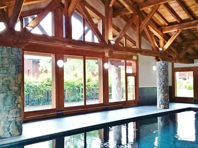 a swimming pool in a house with windows at Charmant duplex 7 pers à Samoëns avec piscine et Wi-Fi - FR-1-815-46 in Samoëns
