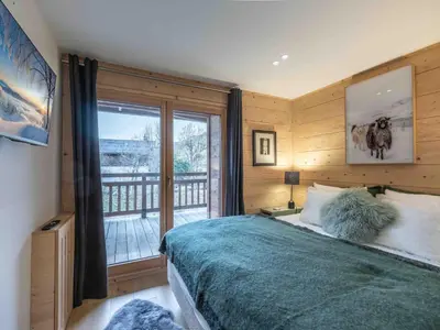 a bedroom with a bed and a large window at Duplex au pied de la télécabine à Megève - 4 chambres - FR-1-569-204 in Megève