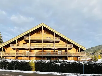 a large wooden building with decks on the side of it at Duplex au pied de la télécabine à Megève - 4 chambres - FR-1-569-204 in Megève