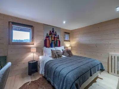 a bedroom with a large bed with wooden walls at Duplex au pied de la télécabine à Megève - 4 chambres - FR-1-569-204 in Megève