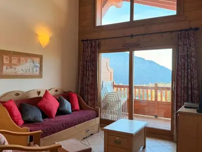 a living room with a couch and a large window at Appartement cosy 3 pièces près des pistes avec parking - FR-1-572-344 in Arâches-la-Frasse