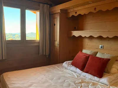 a bedroom with a bed with two red pillows at Appartement cosy 3 pièces près des pistes avec parking - FR-1-572-344 in Arâches-la-Frasse