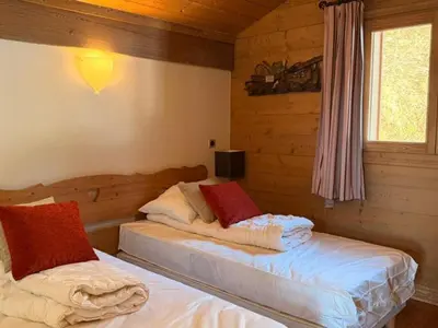 two beds in a room with wooden walls at Appartement cosy 3 pièces près des pistes avec parking - FR-1-572-344 in Arâches-la-Frasse