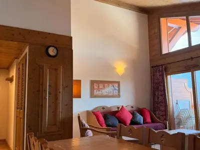 a living room with a couch and a clock on the wall at Appartement cosy 3 pièces près des pistes avec parking - FR-1-572-344 in Arâches-la-Frasse