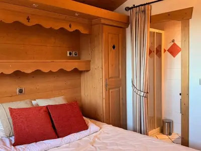 a bedroom with a bed with red pillows at Appartement cosy 3 pièces près des pistes avec parking - FR-1-572-344 in Arâches-la-Frasse