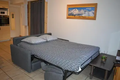 a bed in a room with a picture on the wall at Appartement aux portes de St Gervais in Saint-Gervais-les-Bains