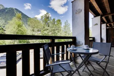 a table and chairs on a balcony with a view at Grand Paradis B11 - Good location & parking in Chamonix-Mont-Blanc