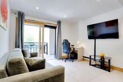 a living room with a couch and a flat screen tv at Grand Paradis B11 - Good location & parking in Chamonix-Mont-Blanc