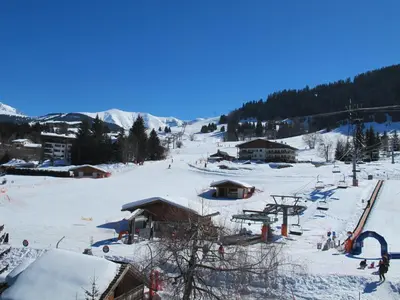 a snow covered ski slope with a ski resort at Megève 105 m2 ensoleillé rénové au pied des pistes in Megève
