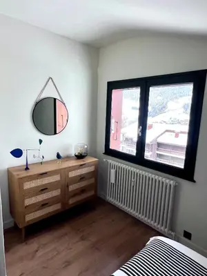 a bedroom with a dresser and a mirror on the wall at Megève 105 m2 ensoleillé rénové au pied des pistes in Megève