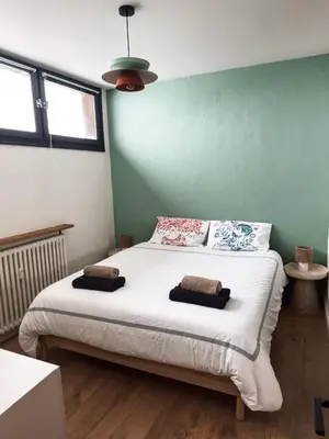a bedroom with a large bed with two pillows on it at Megève 105 m2 ensoleillé rénové au pied des pistes in Megève