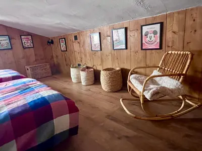 a bedroom with a rocking chair and baskets on the wall at Megève 105 m2 ensoleillé rénové au pied des pistes in Megève