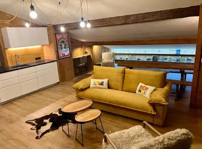 a living room with a couch and a table at Megève 105 m2 ensoleillé rénové au pied des pistes in Megève