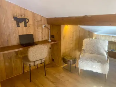a room with a desk with a computer and two chairs at Megève 105 m2 ensoleillé rénové au pied des pistes in Megève