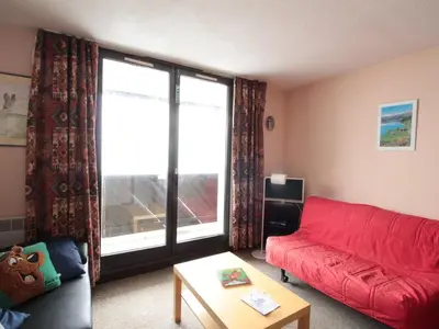 a living room with a red couch and a table at Studio en montagne pour 4 pers, balcon sud, animaux admis - FR-1-687-121 in Arâches-la-Frasse
