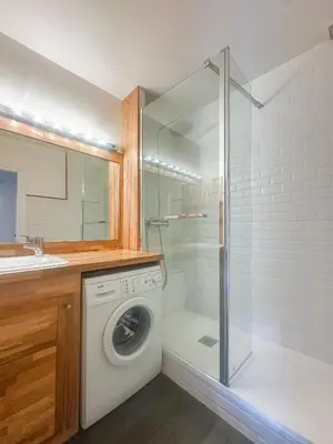 a washing machine in a bathroom with a shower at Melba Megeve emplacement de rêve dans le village au calme in Megève