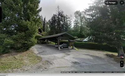a parking lot with a car parked under a canopy at Sapins blancs Megeve in Megève