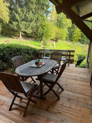 a table and chairs on a wooden deck at Sapins blancs Megeve in Megève
