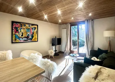 a living room with a couch and a table at Sapins blancs Megeve in Megève