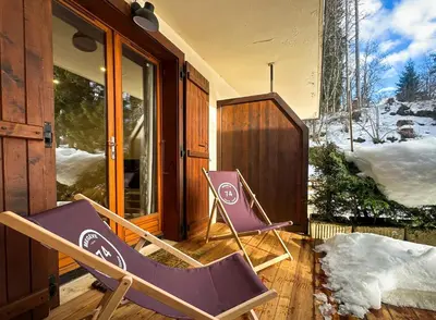 two purple chairs sitting on the porch of a house at Sapins blancs Megeve in Megève