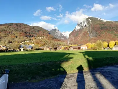 a shadow of a person standing in a field with a mountain at Apparement cosy 4 personnes in Samoëns