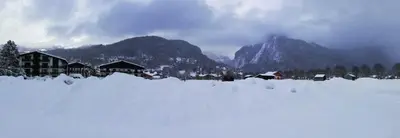a snow covered village with mountains in the background at Apparement cosy 4 personnes in Samoëns