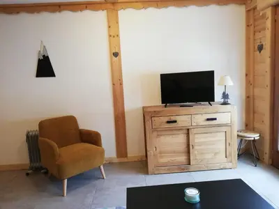 a living room with a television on a wooden dresser at Apparement cosy 4 personnes in Samoëns