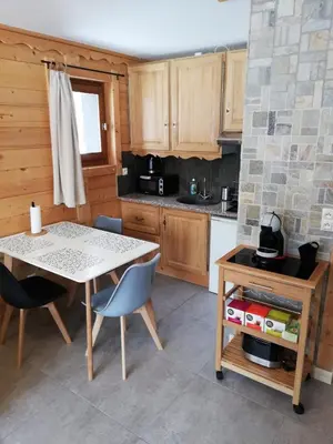 a kitchen with a table and chairs and a stove at Apparement cosy 4 personnes in Samoëns