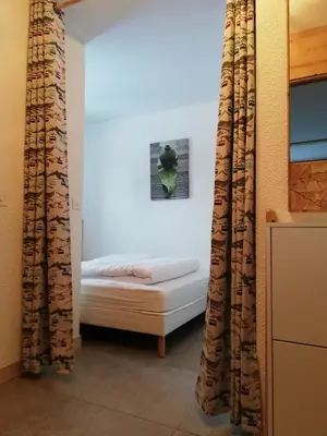 a bed in a room with curtains in a room at Apparement cosy 4 personnes in Samoëns
