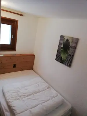a bedroom with a bed and a picture on the wall at Apparement cosy 4 personnes in Samoëns