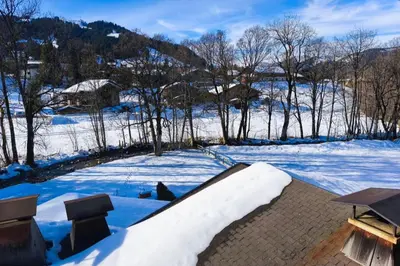 a snow covered yard with a table and chairs at Stay in an ideal mountain chalet! in Megève