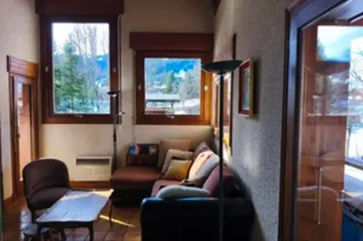 a living room with a couch and chairs and windows at Stay in an ideal mountain chalet! in Megève