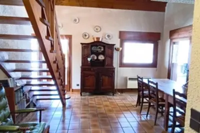 a dining room with a table and a wooden cabinet at Stay in an ideal mountain chalet! in Megève