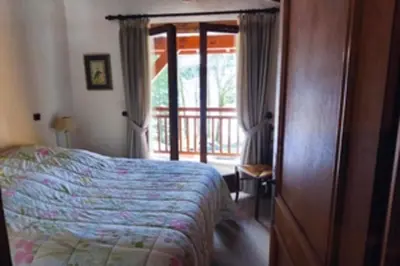 a bedroom with a bed and a sliding glass door at Stay in an ideal mountain chalet! in Megève