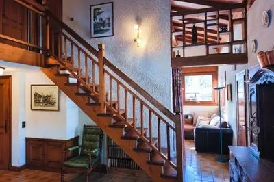 a wooden staircase in a house with a living room at Stay in an ideal mountain chalet! in Megève